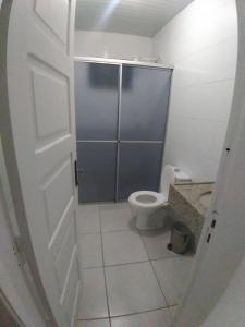 a bathroom with a toilet and a shower stall at Hostel Rota do Vale in Blumenau