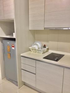 a kitchen with a stove and a refrigerator at Halal Islam Tamu iCity Shah Alam in Shah Alam