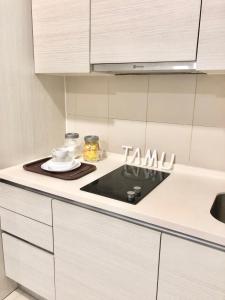 a kitchen with white cabinets and a stove top oven at Halal Islam Tamu iCity Shah Alam in Shah Alam