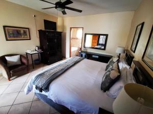 um quarto com uma cama grande e uma ventoinha de tecto em Batter Boys Guest House em Pretoria
