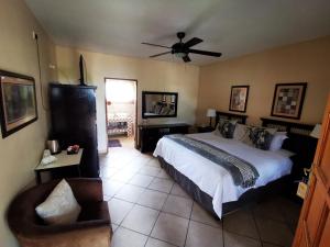 a bedroom with a bed and a ceiling fan at Batter Boys Guest House in Pretoria