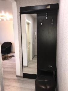 einen schwarzen Spiegel in einem Zimmer mit einem schwarzen Stuhl in der Unterkunft Квартира Апполо in Dnipro