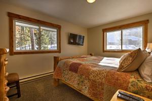 ein Schlafzimmer mit einem Bett und zwei Fenstern in der Unterkunft Keystone Home on Snake River with Hot Tub and Views! in Keystone
