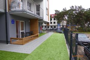 a balcony of a building with a green lawn at APARTAMENT PRZY PLAŻY in Rowy