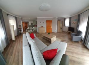 salon z białą kanapą i czerwonymi poduszkami w obiekcie Pannonia Apartman w mieście Ostrzyhom