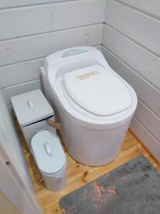a bathroom with a toilet and a trash can at Saunaboat Haikara in Jorvas