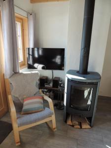 uma sala de estar com uma lareira, uma cadeira e uma televisão em Pradamont 09 em Grimentz