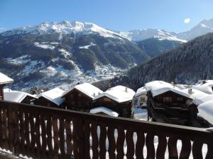 uma vista para uma montanha com casas cobertas de neve em Pradamont 09 em Grimentz