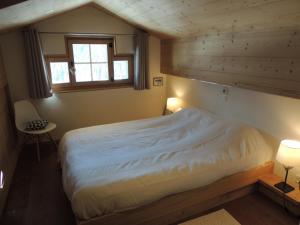 une chambre avec un grand lit avec une fenêtre dans l'établissement Pradamont 09, à Grimentz