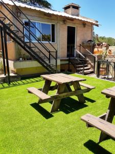 una mesa de picnic en el césped frente a una casa en Los Carolinos Departamentos en Villa Carlos Paz