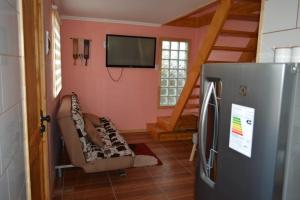 Elle comprend un salon avec un canapé, une télévision et un réfrigérateur. dans l'établissement Sima Michi, à Puerto Natales