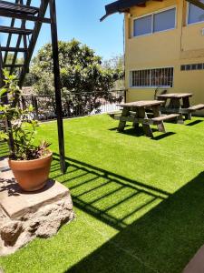 a picnic table and bench in a grassy yard at Los Carolinos Departamentos in Villa Carlos Paz