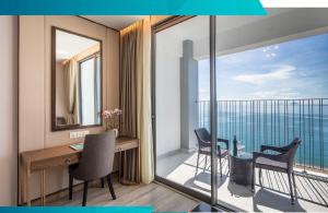 een kamer met een bureau en een balkon met uitzicht bij Star Beach Panorama in Nha Trang
