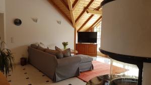 a living room with a couch and a flat screen tv at Ferienwohnungen Kamino in Häusern