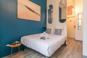 a bedroom with a white bed with blue walls at Apartments WS Marais - République in Paris