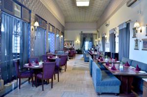 um restaurante com mesas e cadeiras num quarto em Hotel Merwara Estate- A Luxury Heritage Resort em Ajmer
