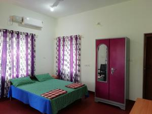 a bedroom with a bed and a purple door at kannur west beach homestay in Kannur