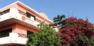 a building with flowering trees in front of it at Nautilus Aparthotel in Santa Maria