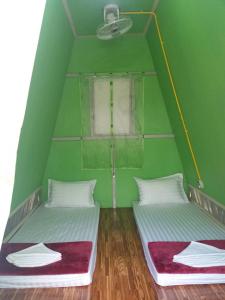 2 letti in una camera verde con finestra di ฺBankunyaiy Resort a Ko Yao Yai