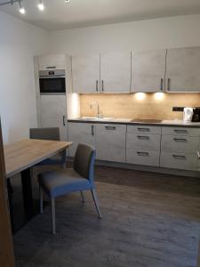 eine Küche mit einem Holztisch sowie einem Tisch und Stühlen in der Unterkunft Appartement Franz in Zell am Ziller
