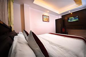 Een bed of bedden in een kamer bij Greatwall International Hotel
