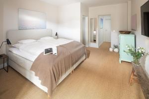 a bedroom with a large bed with a book on it at Friedrich Inn in Norderney