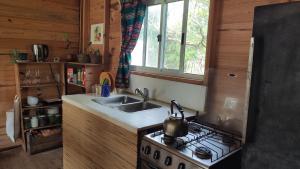 een keuken met een fornuis, een wastafel en een raam bij Verdemar in La Paloma
