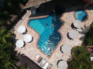 una vista aérea de una piscina con sombrillas blancas en Suite Ilhaflat, en Ilhabela