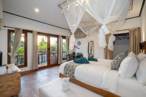 a bedroom with a large white bed with curtains at Breeze Villa in Nusa Lembongan