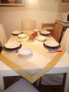 a table with white plates and utensils on it at Holiday Home Spalato in Split