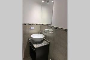a bathroom with a sink and a mirror at Departamento céntrico, pileta cochera moderno y lujoso in Villa Carlos Paz +11 photos