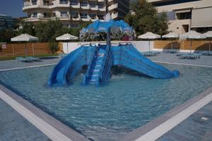 
a blue and white pool with a blue chair at Blue Sea Beach Resort in Faliraki
