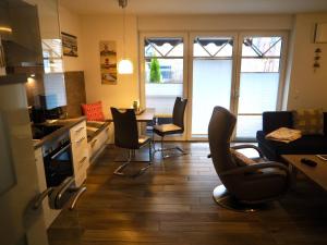 a kitchen and living room with chairs and a table at Nordlicht 25 in Greetsiel