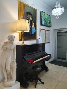 a living room with a piano and a painting on the wall at Hotel San Giorgio in Bergamo