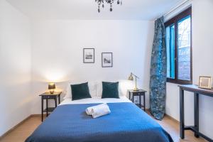 um quarto com uma cama azul com duas mesas de cabeceira em Haus Ormesini em Veneza