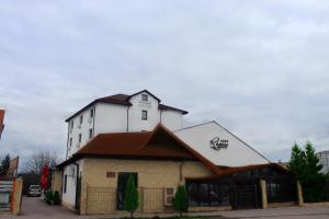 ein großes weißes Gebäude mit braunem Dach in der Unterkunft Pensiunea Romeo Resort in Focşani