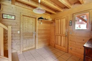 a log cabin hallway with a door and a window at CHALET WIFI - LE BIOT - 8 PERSONNES - CHALET MORAND in Le Biot