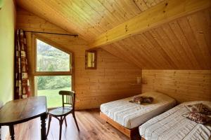 een kamer met 2 bedden, een tafel en een raam bij CHALET WIFI - LE BIOT - 8 PERSONNES - CHALET MORAND in Le Biot