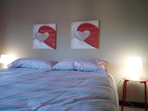 a bedroom with two hearts paintings on the wall at casa vacanze morà 2 in Roccaforte Mondovì