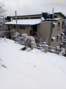 a house in the snow with snow at Viewtiful Homestay in Mukteswar