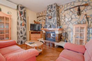 a living room with two couches and a fireplace at Cortijo la Encina in Sayalonga