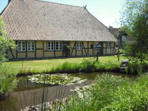 een huis met een vijver voor een gebouw bij Landhaus Kiesow in Suderburg