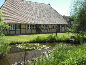 a house with a pond in front of a building at Landhaus Kiesow in Suderburg