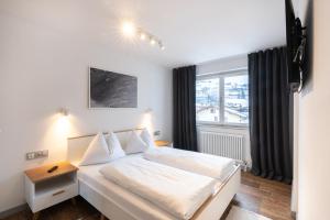 mała sypialnia z łóżkiem i oknem w obiekcie Kaprun Apartments w Kaprunie