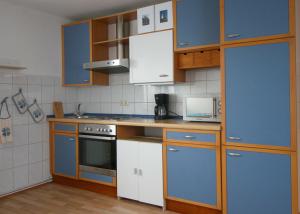 a kitchen with blue cabinets and a stove top oven at Ferienwohnung Carla in Celle