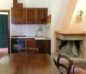 cocina con mesa de madera y chimenea en Agriturismo Tognoloni en Gubbio