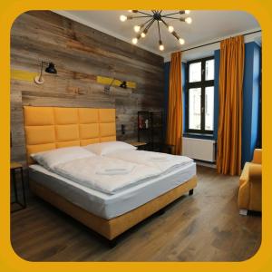 トルンにあるApartamenty Szeroka 23の大きなベッドと木製の壁が備わるベッドルーム1室が備わります。