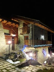 a stone building with a balcony at night at La Luge in Saint-Christophe