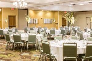 un salón de banquetes con mesas y sillas blancas en Holiday Inn & Suites Bolingbrook, an IHG Hotel, en Bolingbrook