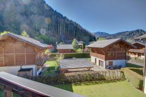 Una vista de un patio con dos edificios de madera. en APPARTEMENT PROCHE MORZINE CENTRE ET REMONTEES MECANIQUES - Orée de Morzine 24A, en Montriond